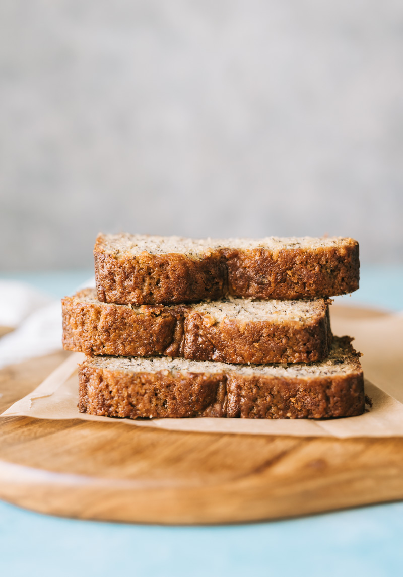 banana bread slices stacked on a wood cutting board