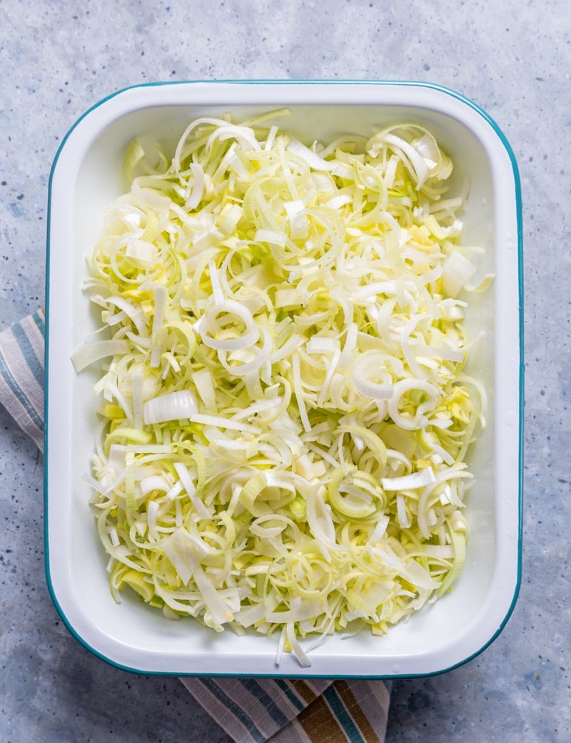 metal tray filled with sliced raw leeks