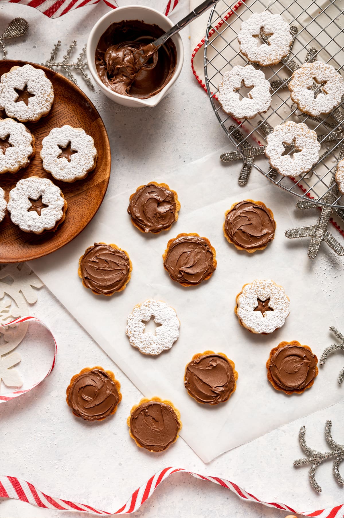 cookies with swirls of chocolate spread on them, chocolate filled sandwich cookies on a wood plate red and white ribbon