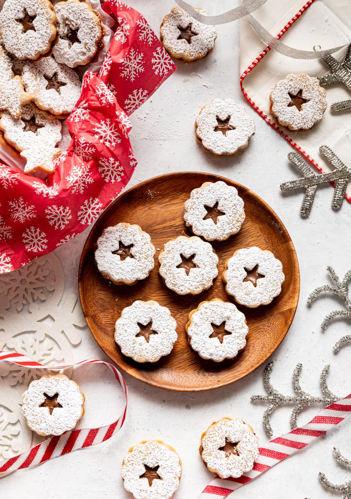 chocolate filled sandwich cookies on a brown plate, red and white ribbon