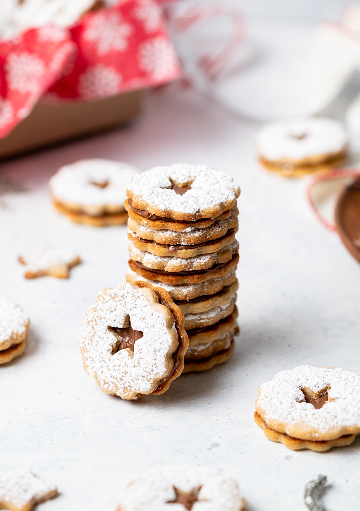 stack of chocolate cinnamon linzer cookies with powdered sugar