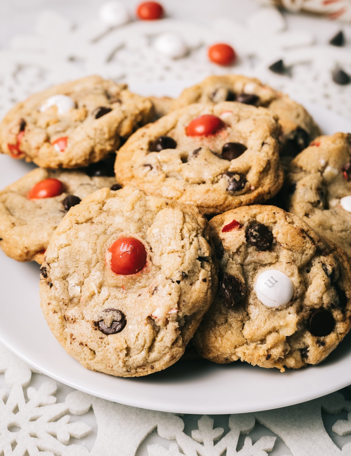 chocolate chip cookies with red and white M&M candies on a white plate