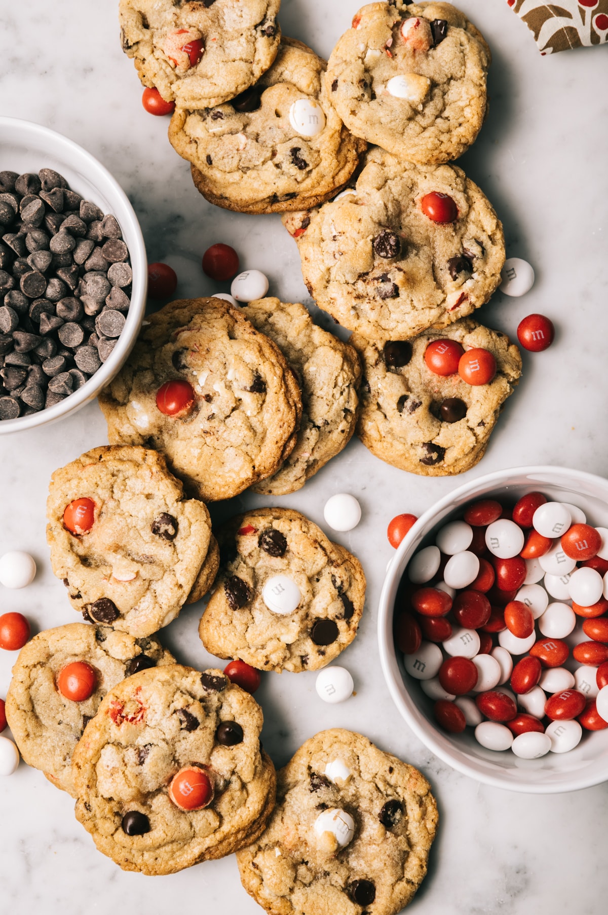 chocolate chip cookies with red and white M&Ms bowl of chocolate chips bowl of red and white M&Ms