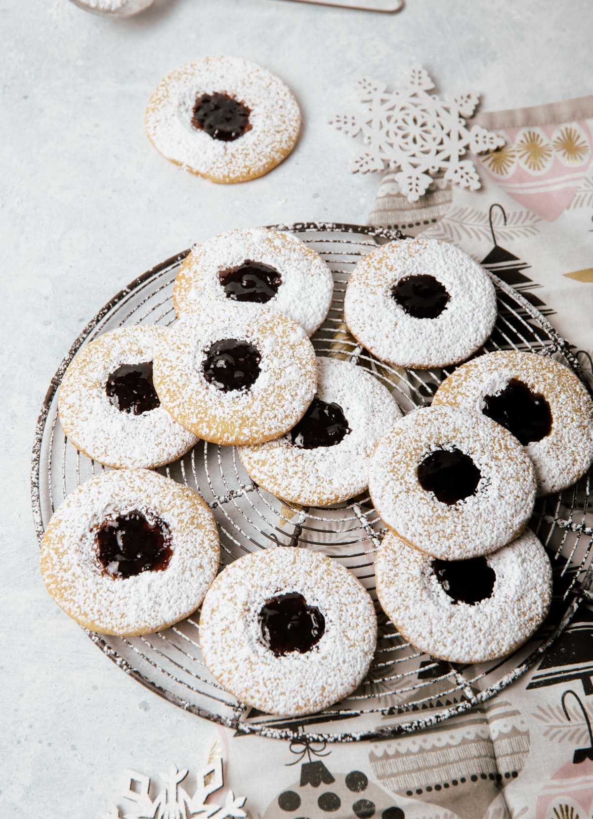 round sandwich cookies with dark purple jam layered on a wire rack