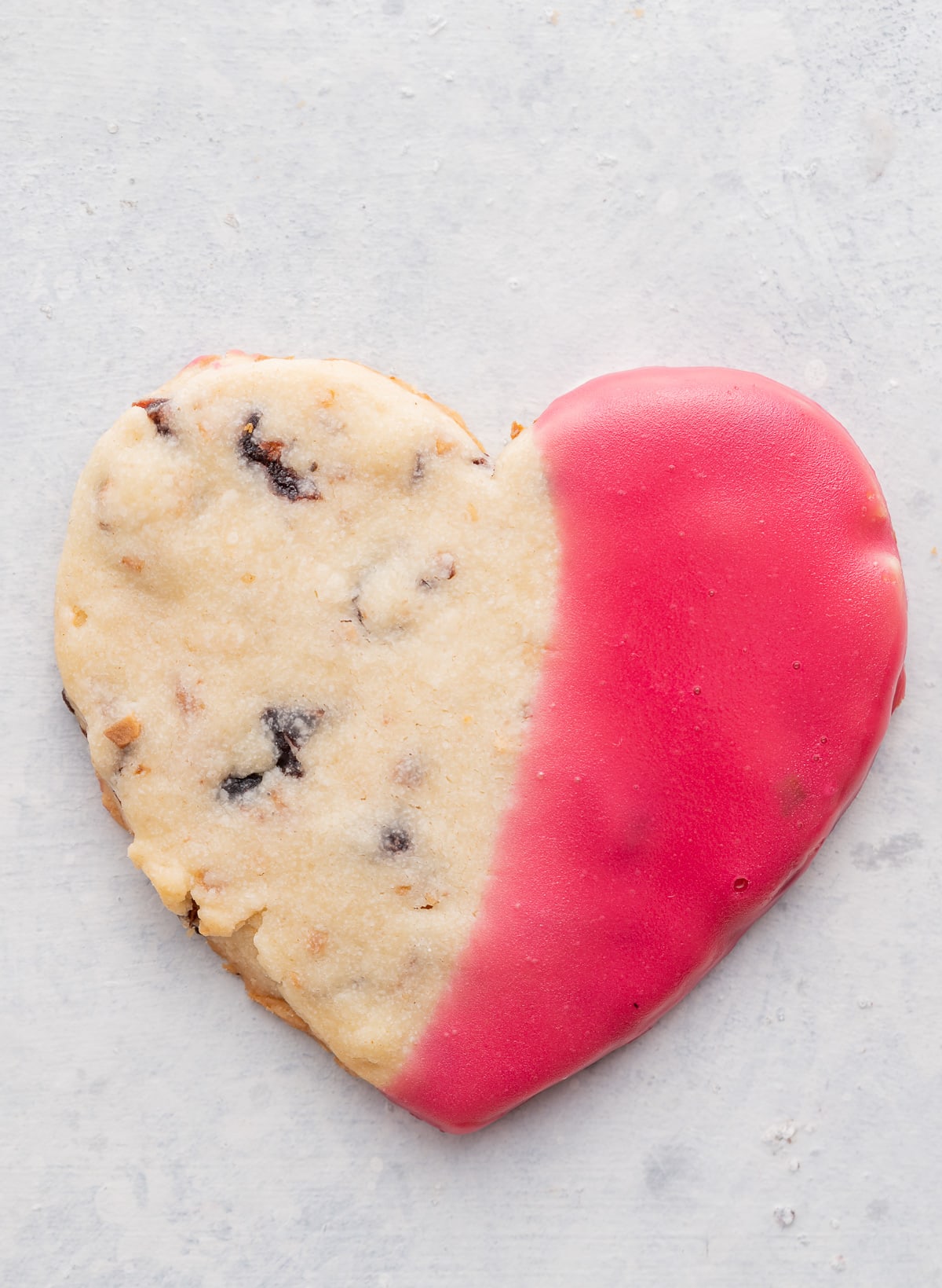 Heart shaped shortbread cookie half dipped in pink icing