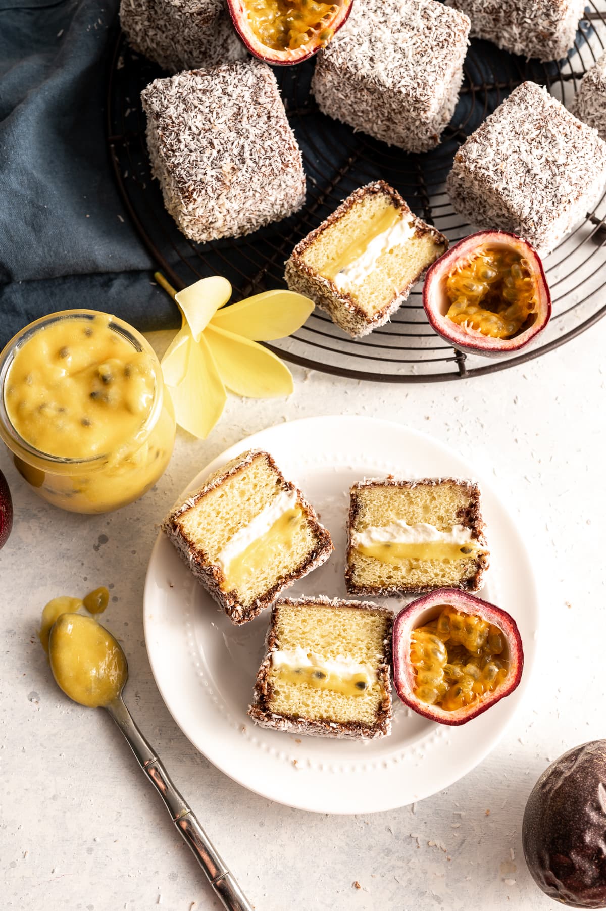 yellow passion fruit curd and white whipped cream filled yellow cake sandwiches with chocolate and coconut fresh passion fruits cut in half