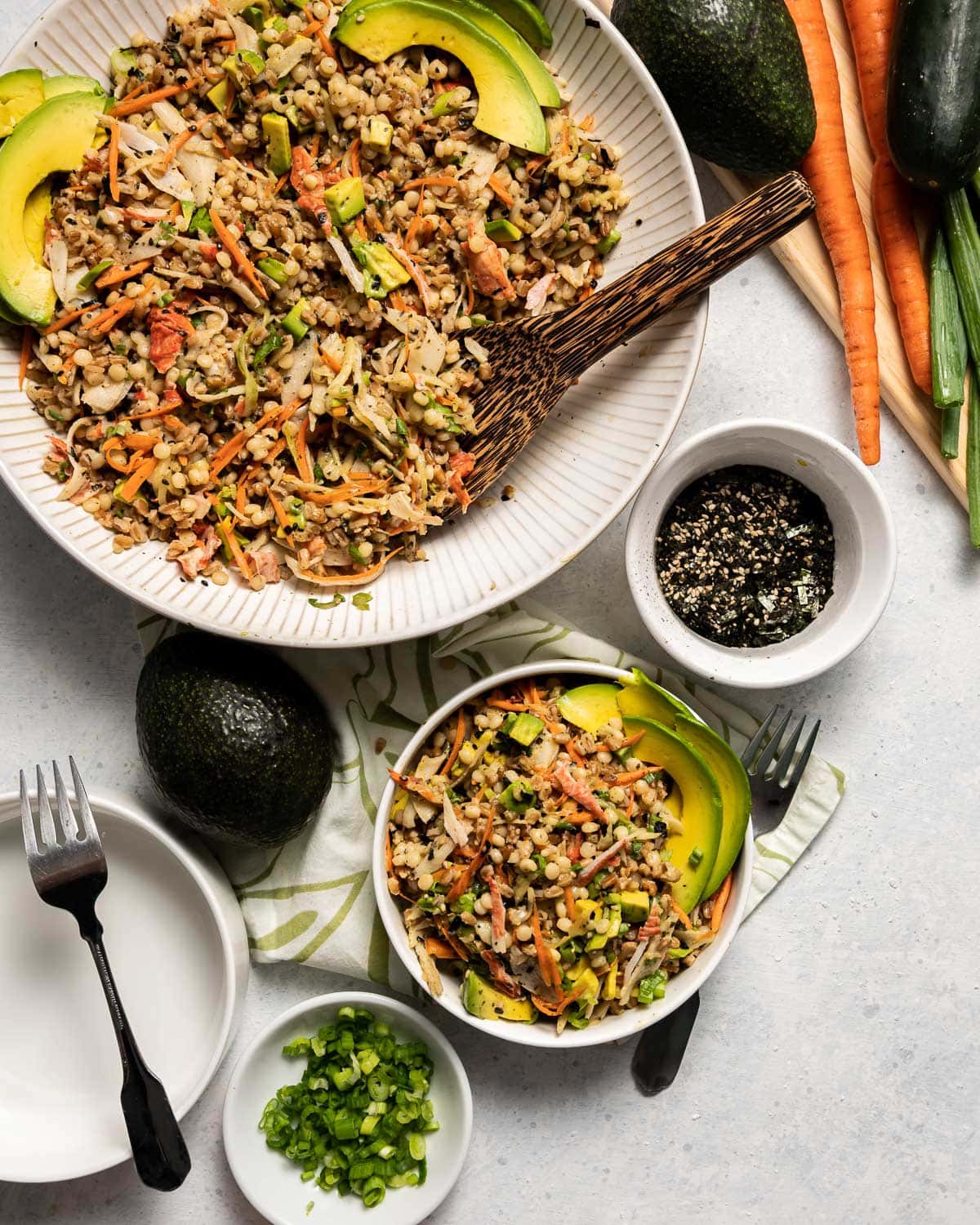 california roll salad with mixed grains and vegetables in white bowls bowl or green onion whole avocado bowl of seaweed seasoning