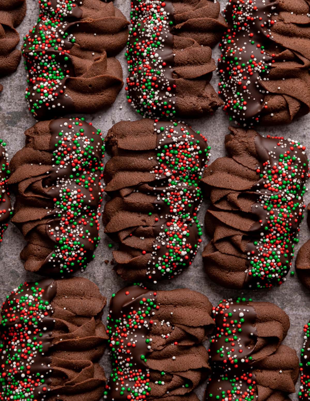 chocolate viennese butter cookies half dipped in chocolate with red green and white sprinkles viennese whirls