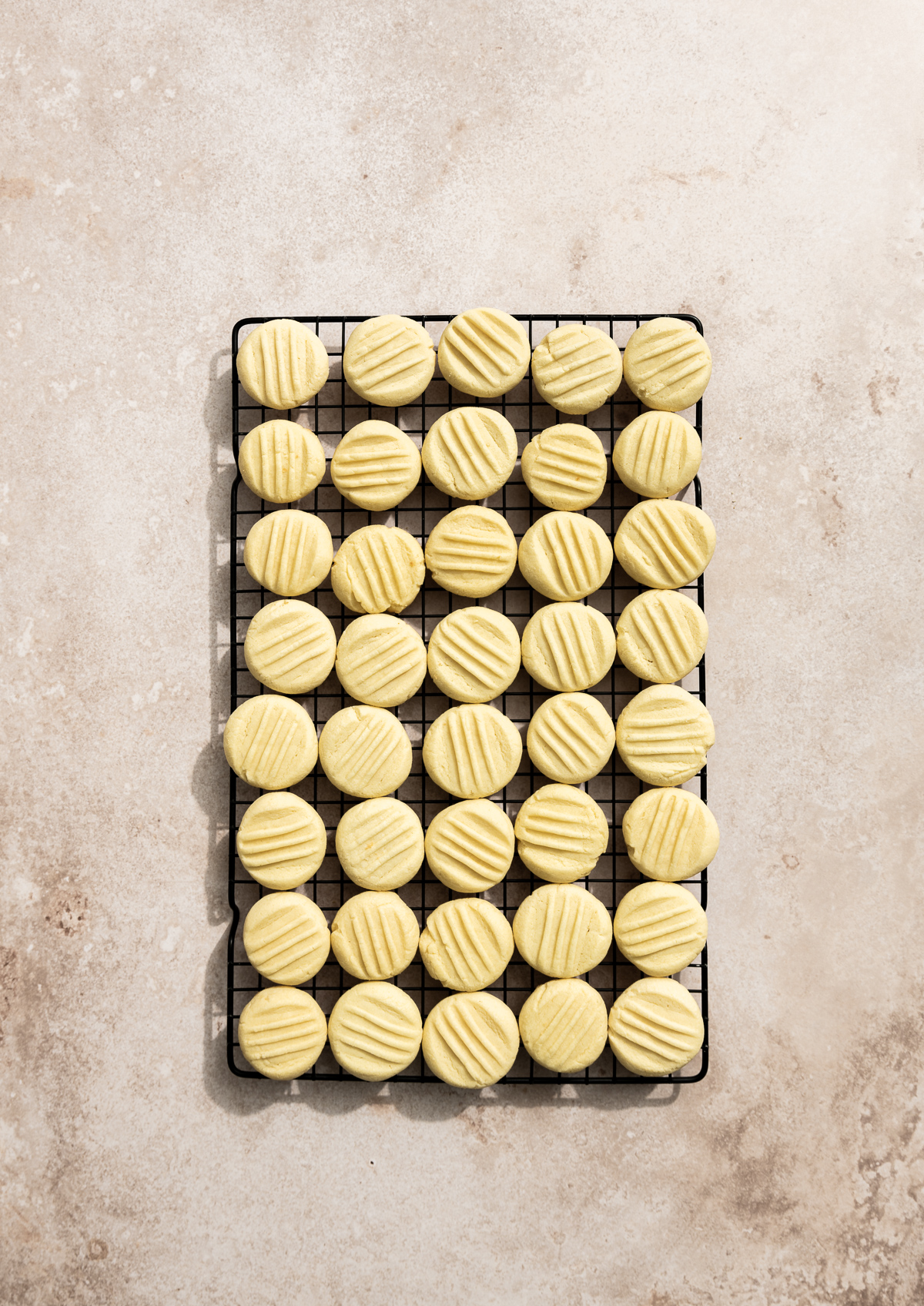 round butter cookies with fork marks on a wire cooling rack