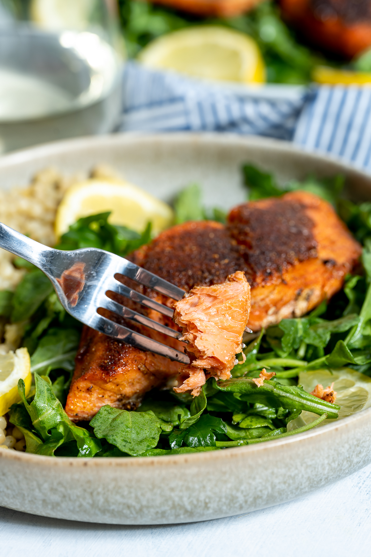 salmon fillet on plate over bed of arugula 