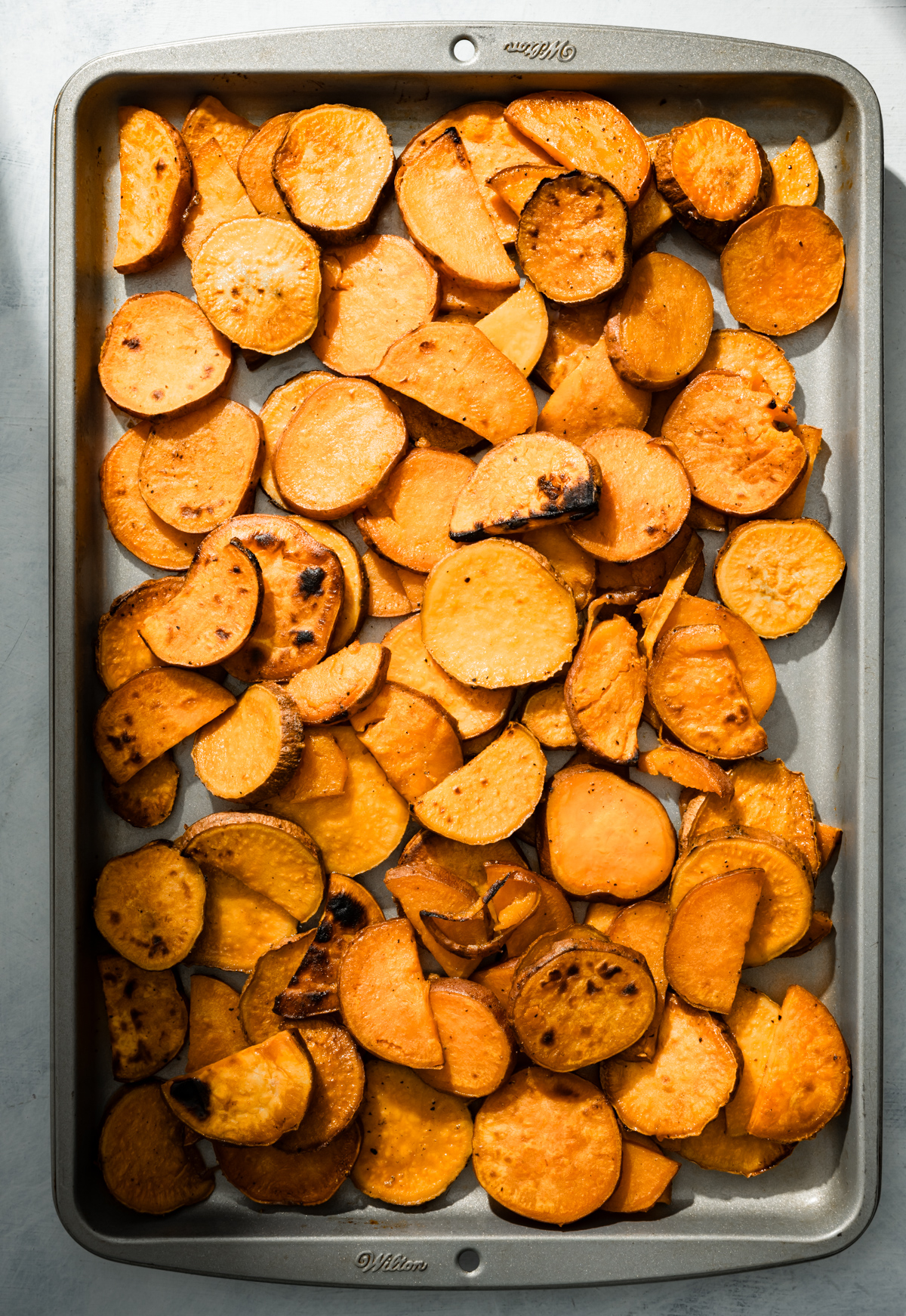 sliced baked sweet potatoes on a baking sheet