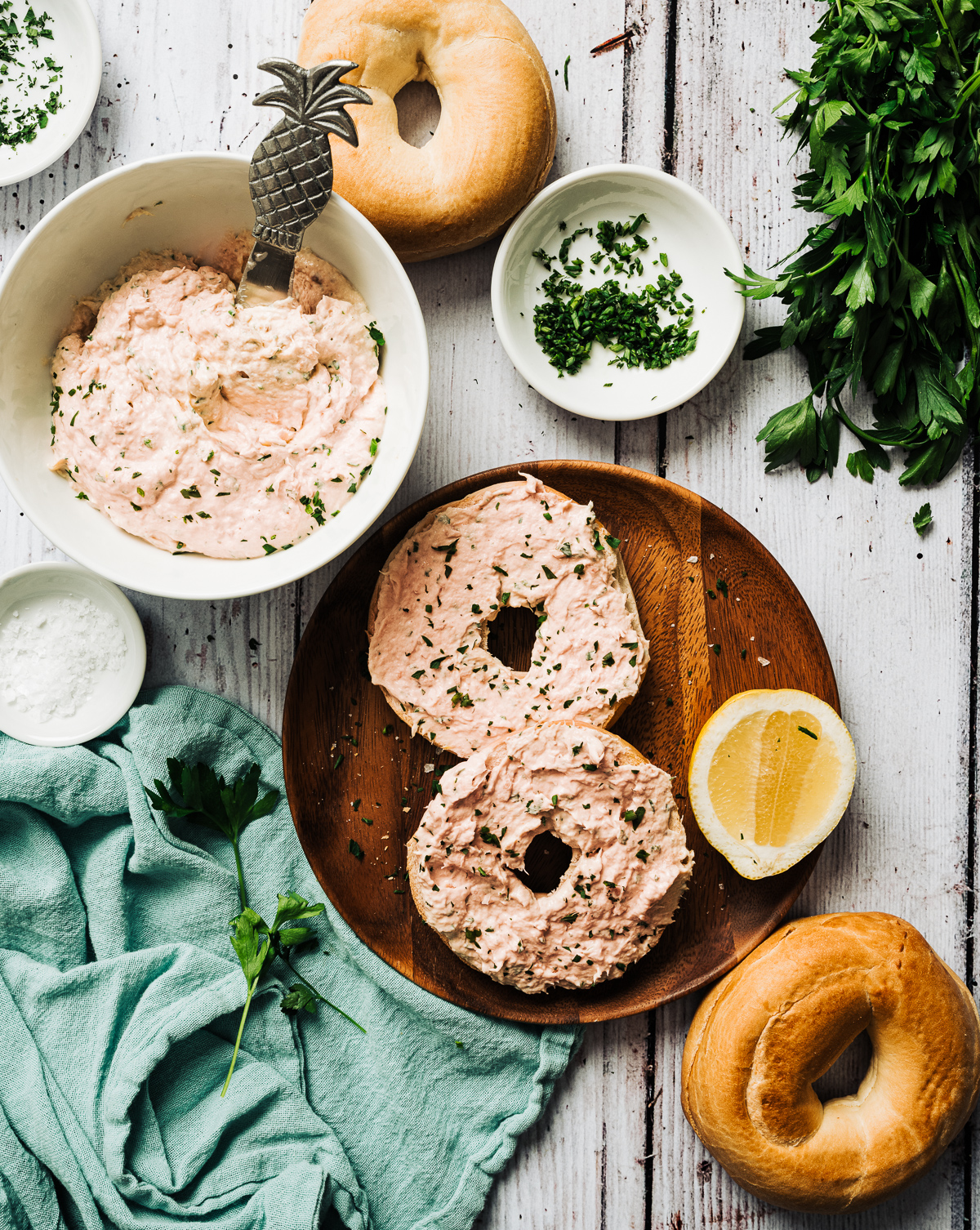  bagels with smoked salmon spread bowl of salmon spread lemon slice parley salt aqua napkin