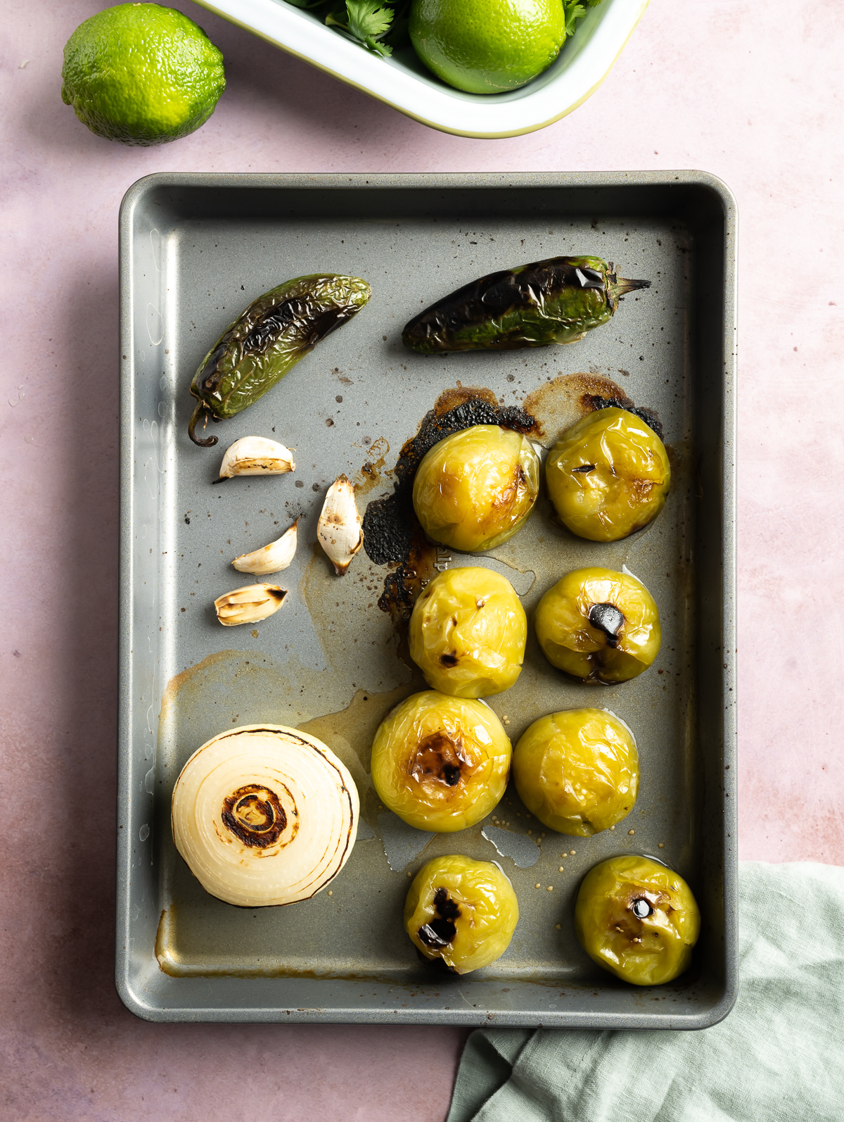 tray with roasted whole tomatillos white onion garlic cloves jalapeños