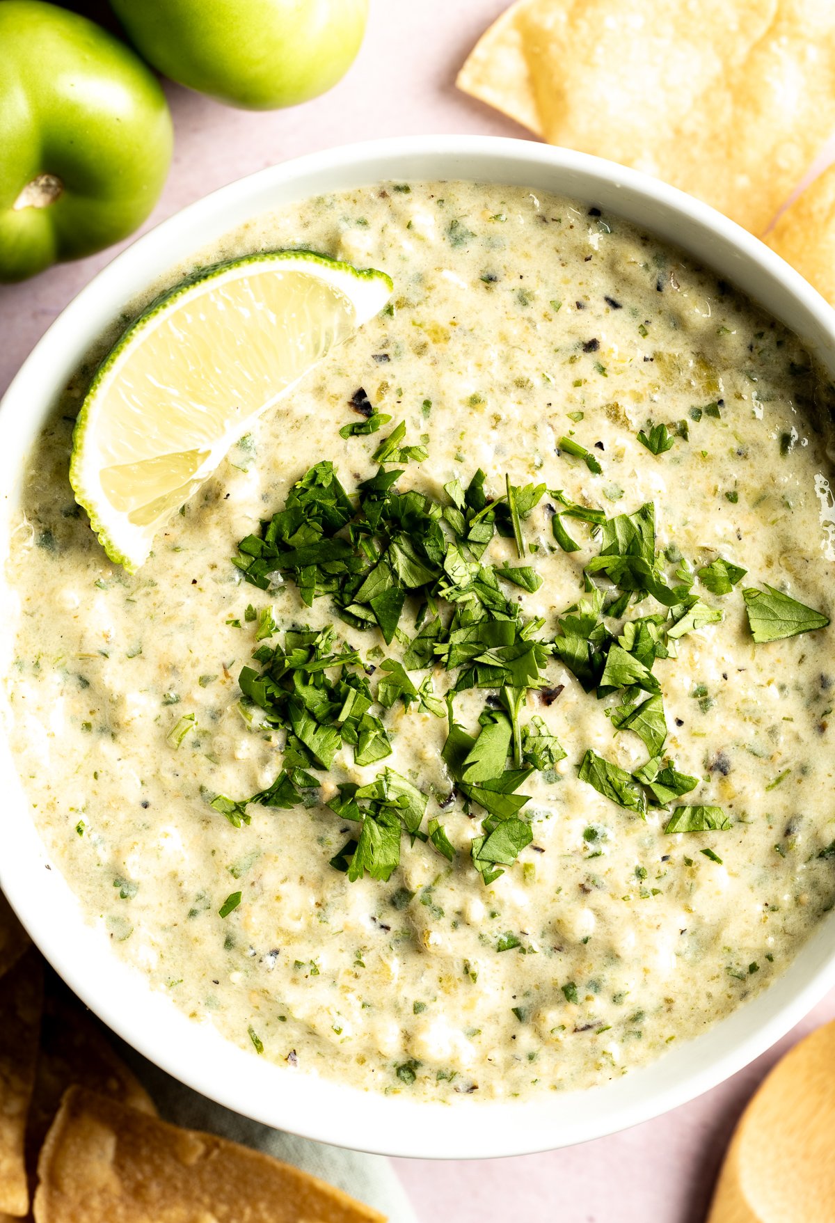 bowl of green salsa with cilantro limes chips 