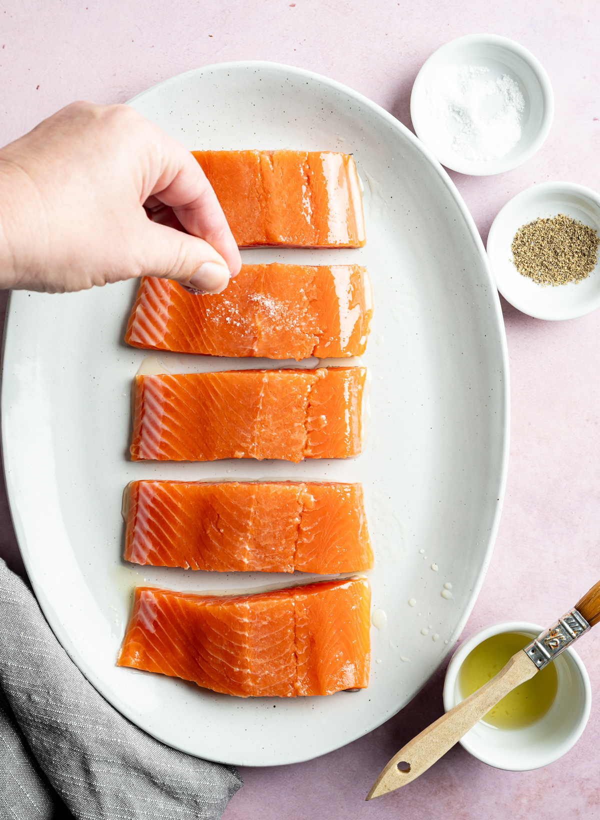 salt being sprinkled on salmon fillets