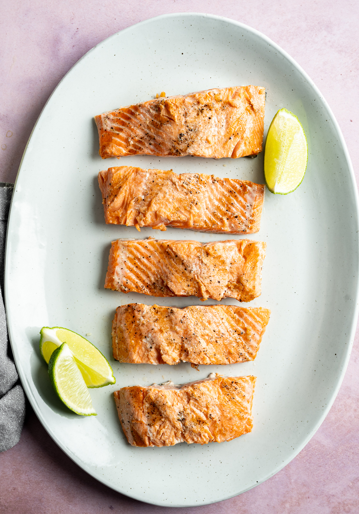 grilled coho salmon fillets on platter with lime slices