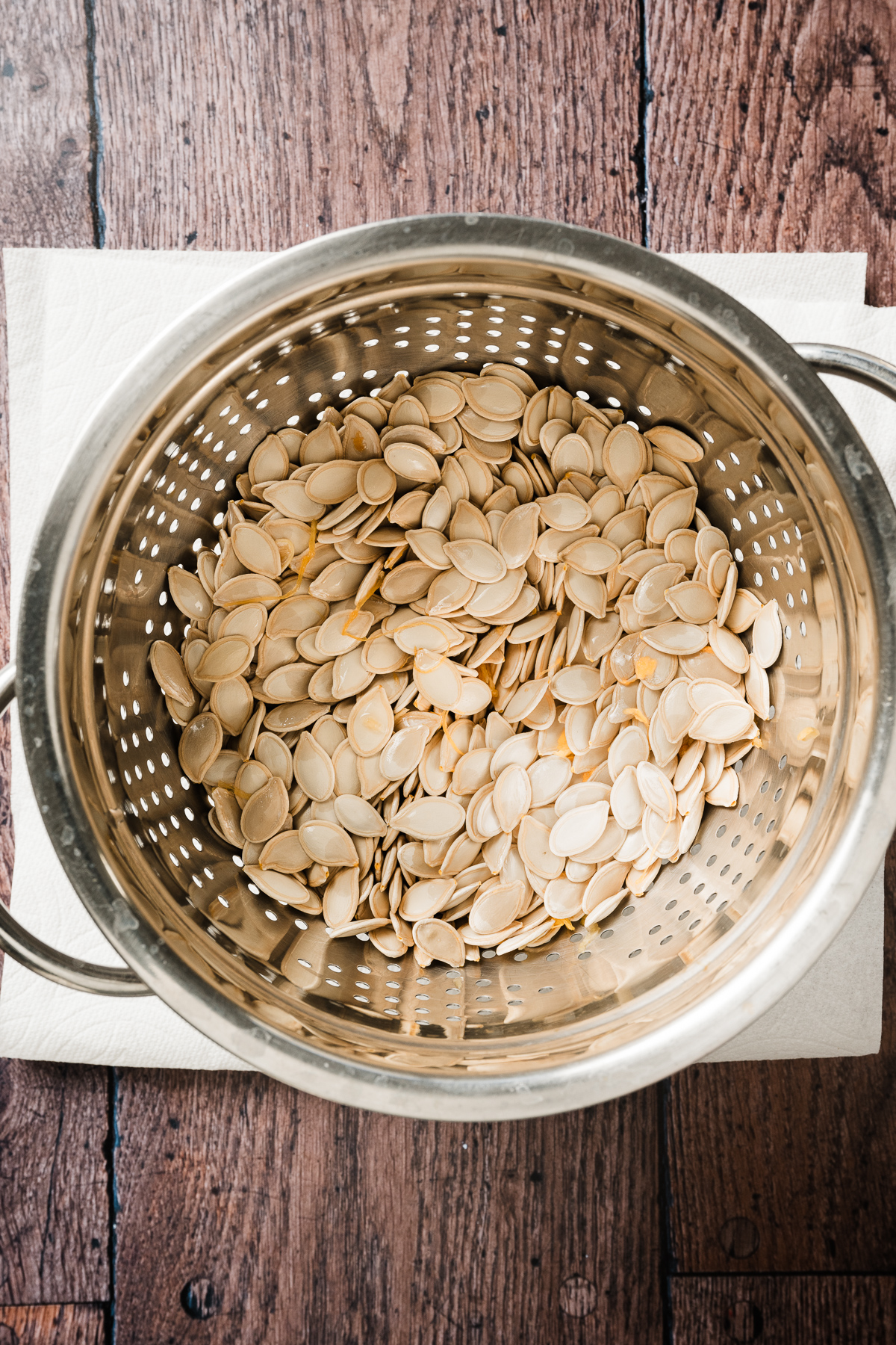 colander with raw pumpkin seeds