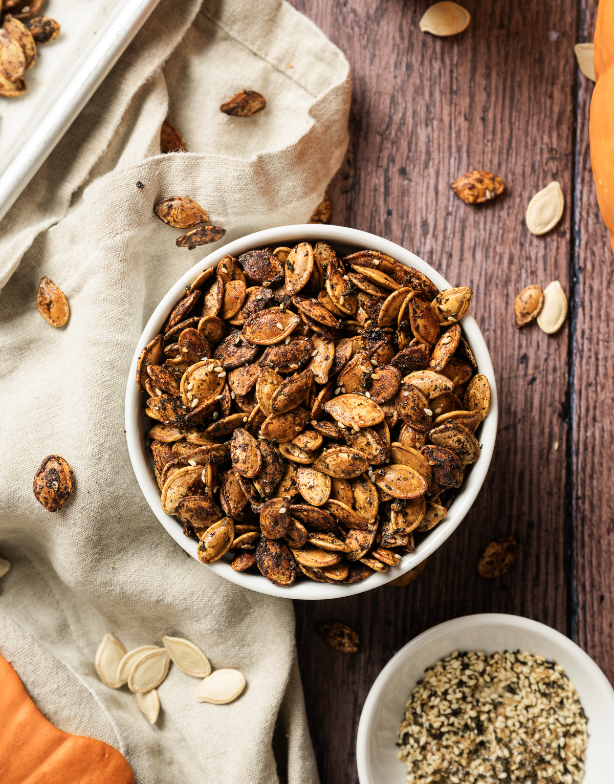 bowl of golden brown furikake seasoned pumpkin seeds tan napkin