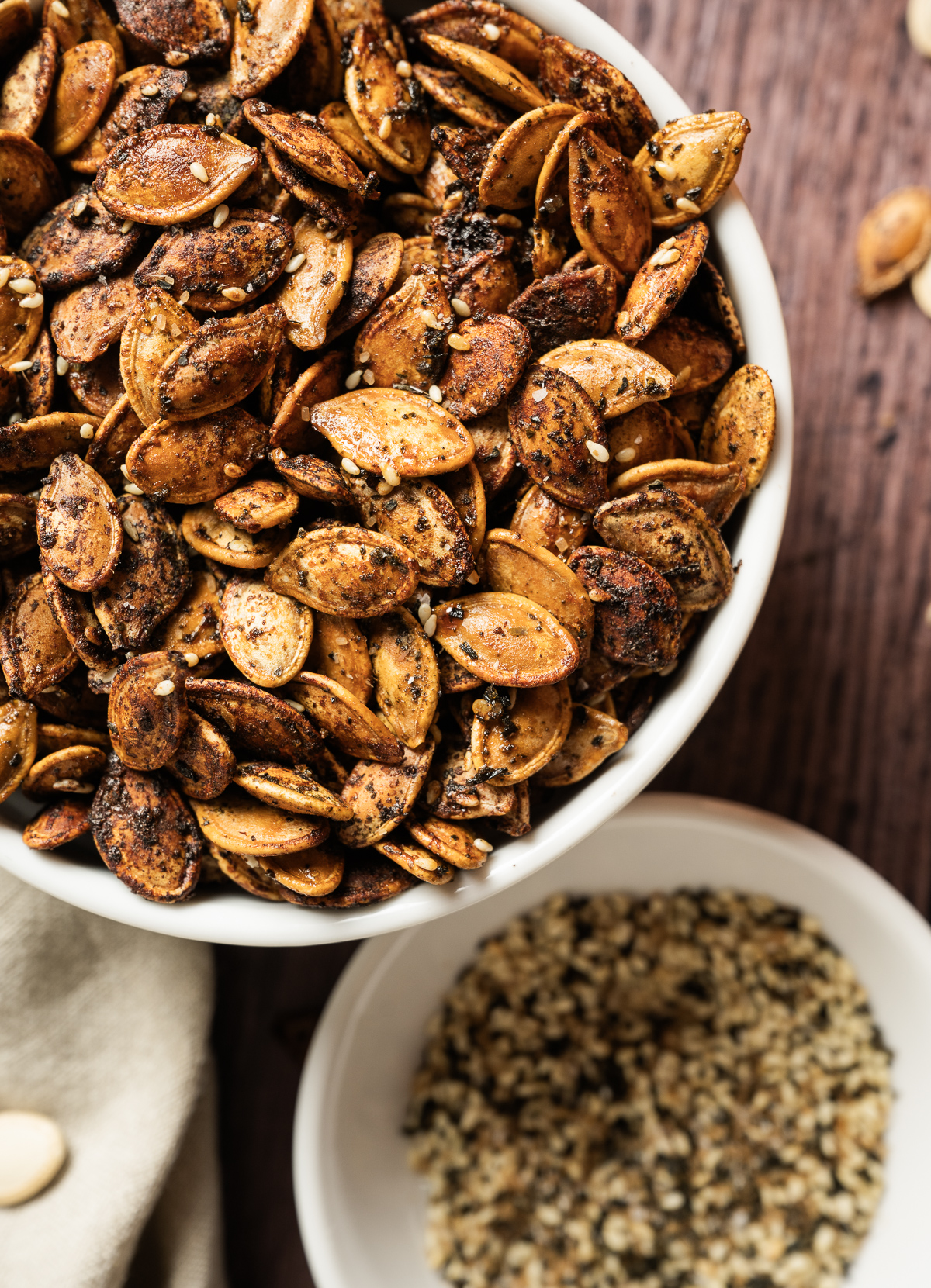 bowl of roasted pumpkin seeds small bowl of furikake seasoning 