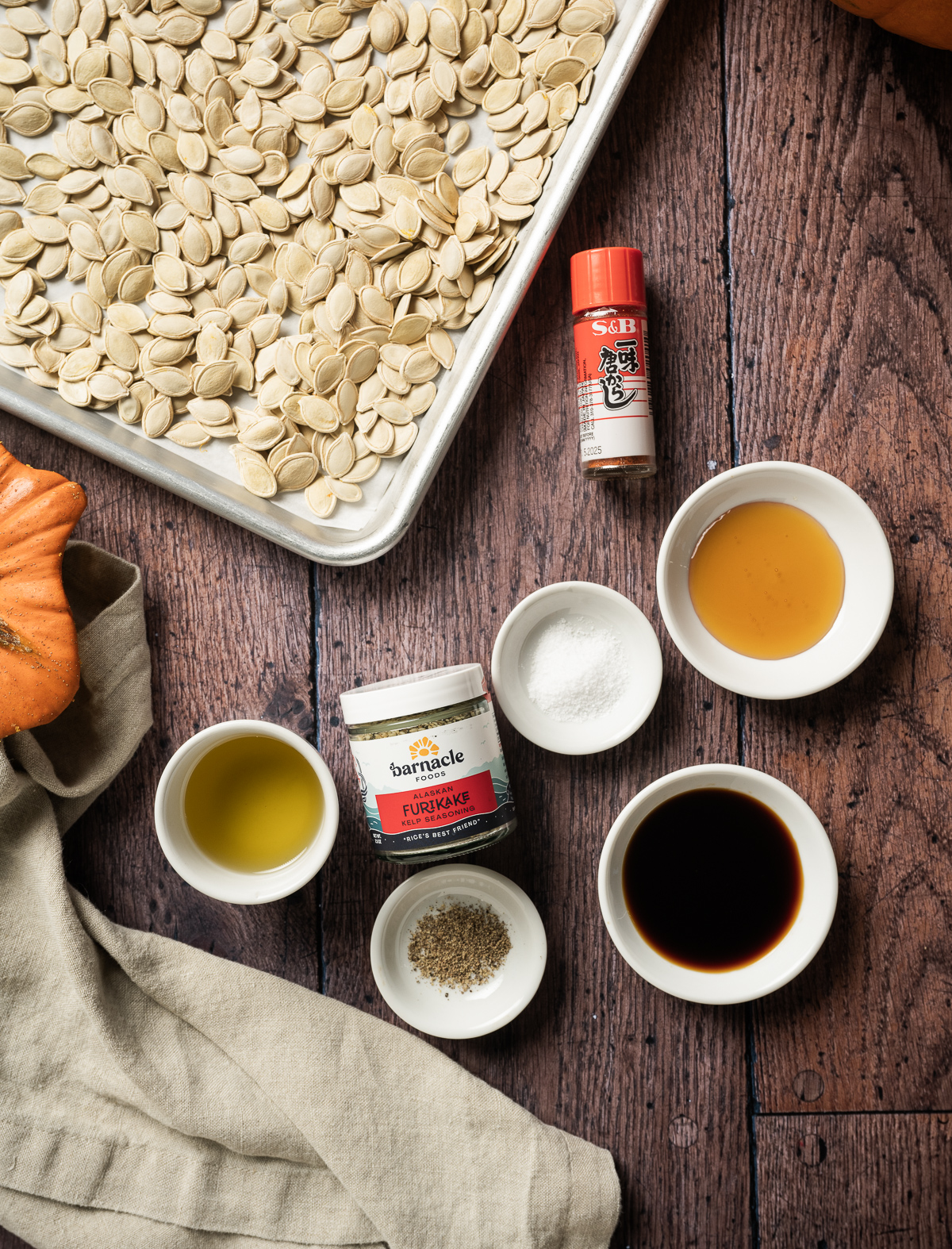 tray of pumpkin seeds bowls of soy sauce honey salt pepper oil jar of furikake jar or togarashi