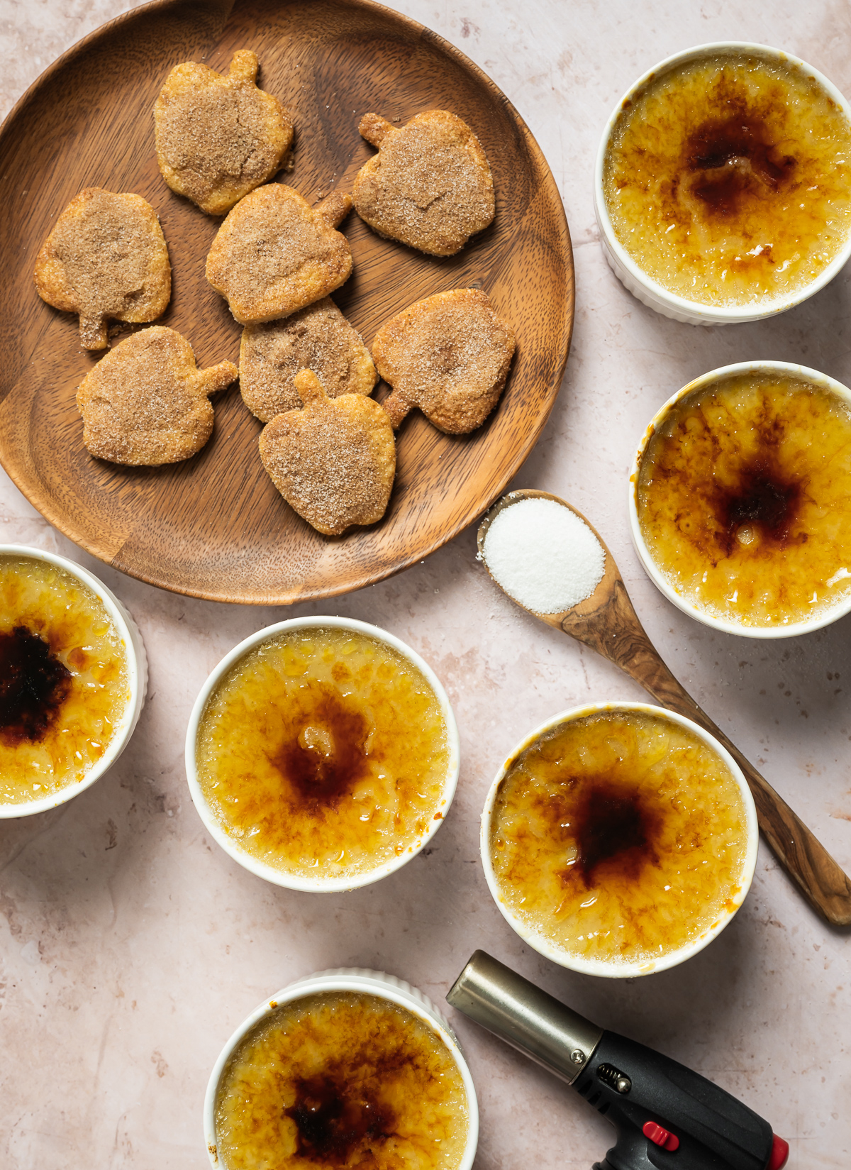 apple pie crème Brûlée with spiced apple shaped pie crust cookies wood plate spoons kitchen torch