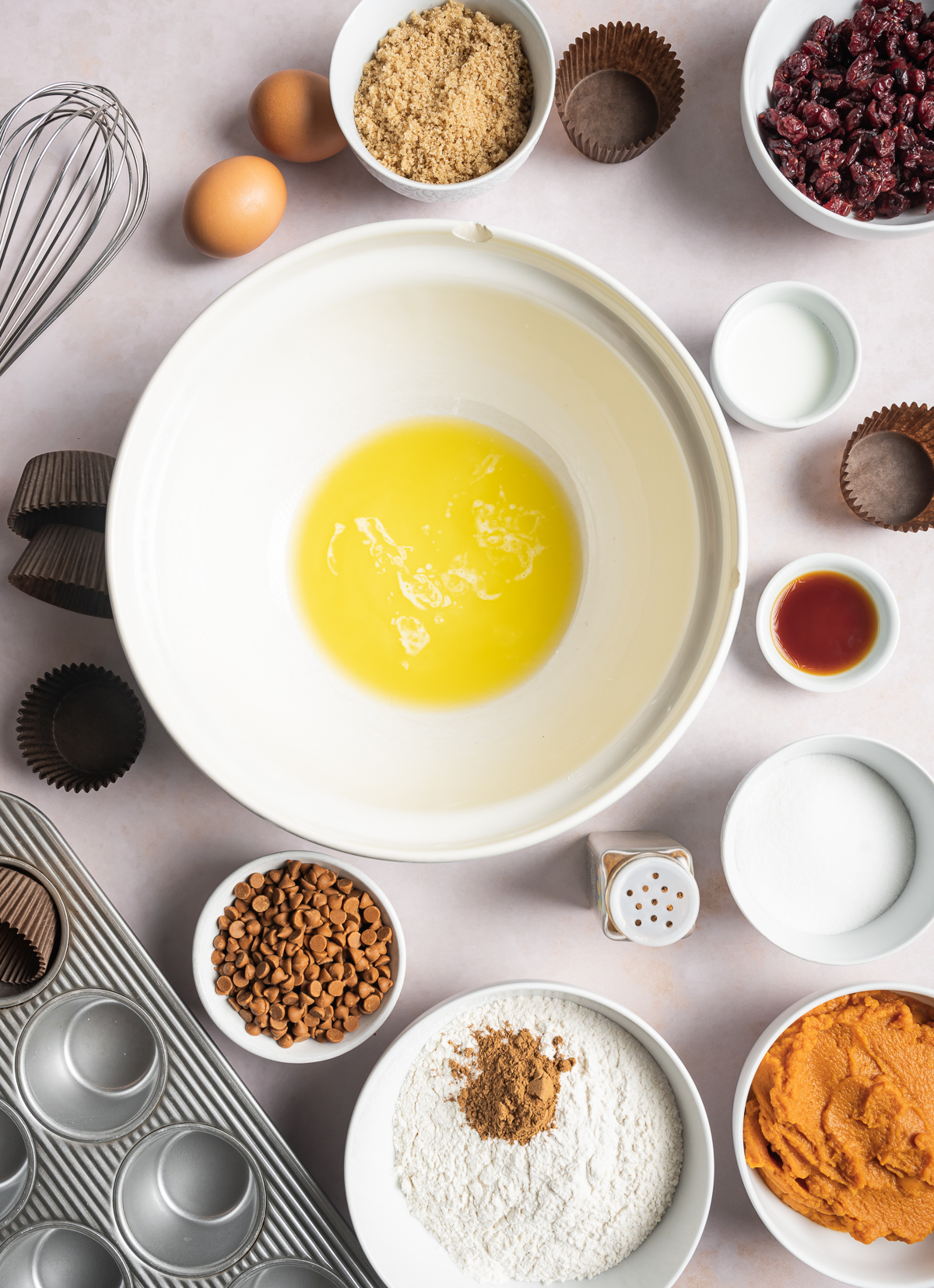 melted butter in a bowl, various bowls of separate muffin ingredients