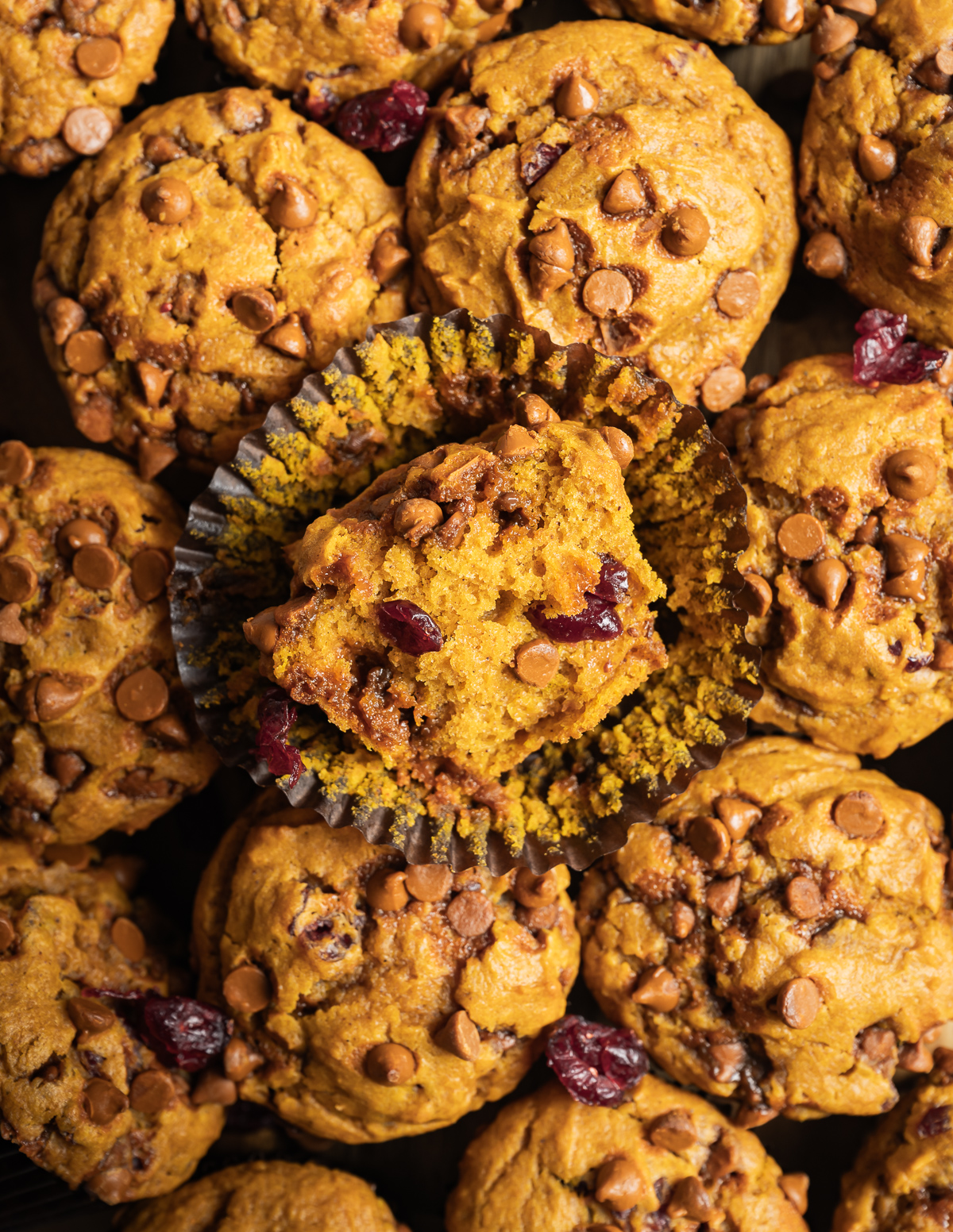 cinnamon 
pumpkin muffins with brown liners inn a pile one cut in half