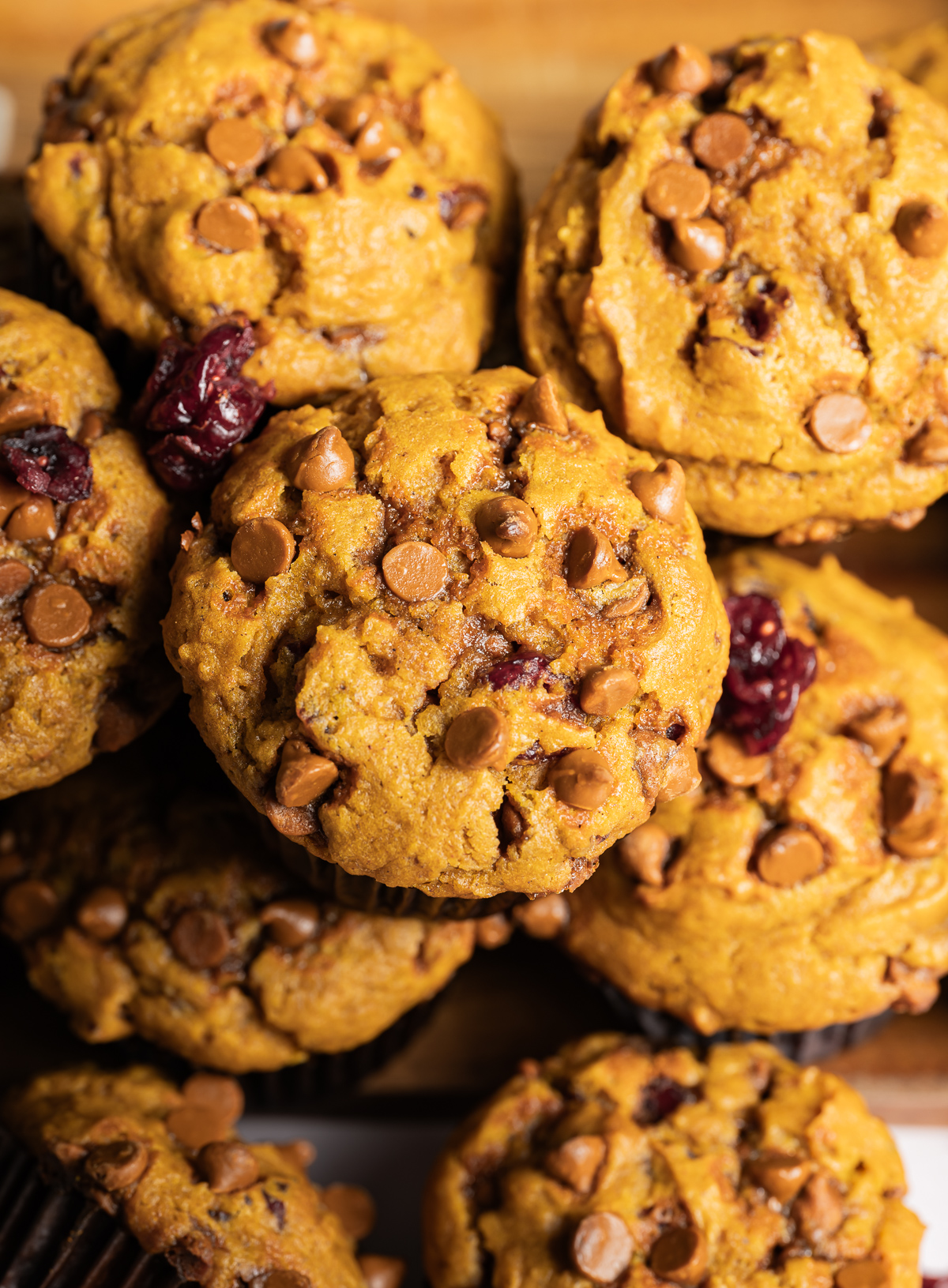 a pile of cinnamon pumpkin muffins in brown paper liners