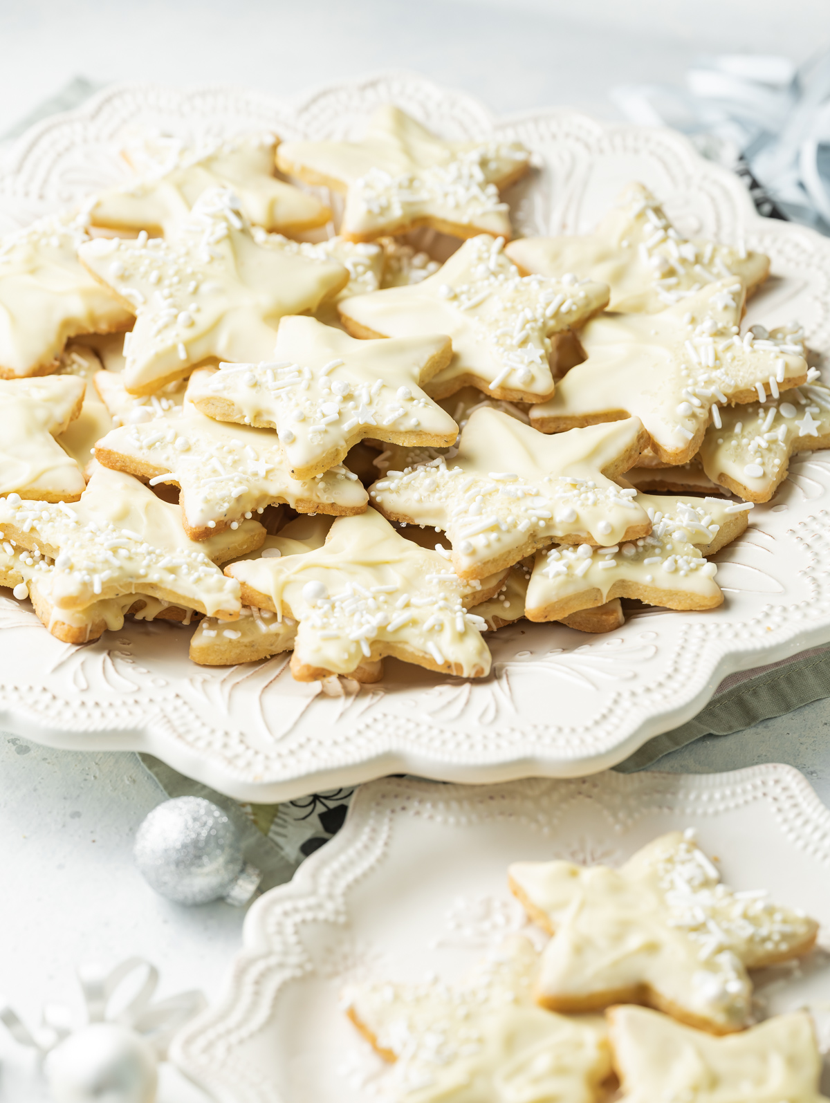 star shaped white chocolate dipped cardamom shortbread cookies on a white plate