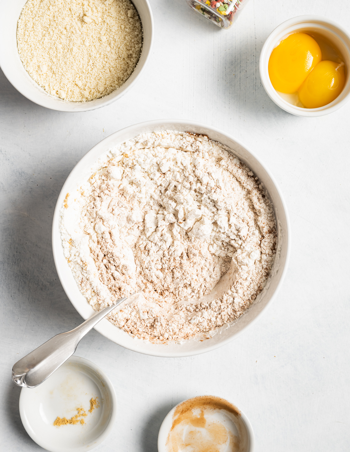 spices mixed into a bowl of flour bowl of almond flour bowl of egg yolks