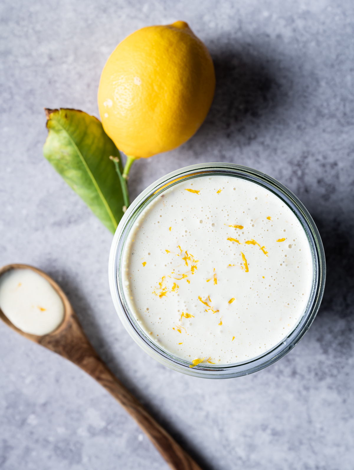 meyer lemon caesar dressing in a weck jar with lemon zest whole meyer lemon wooden spoon