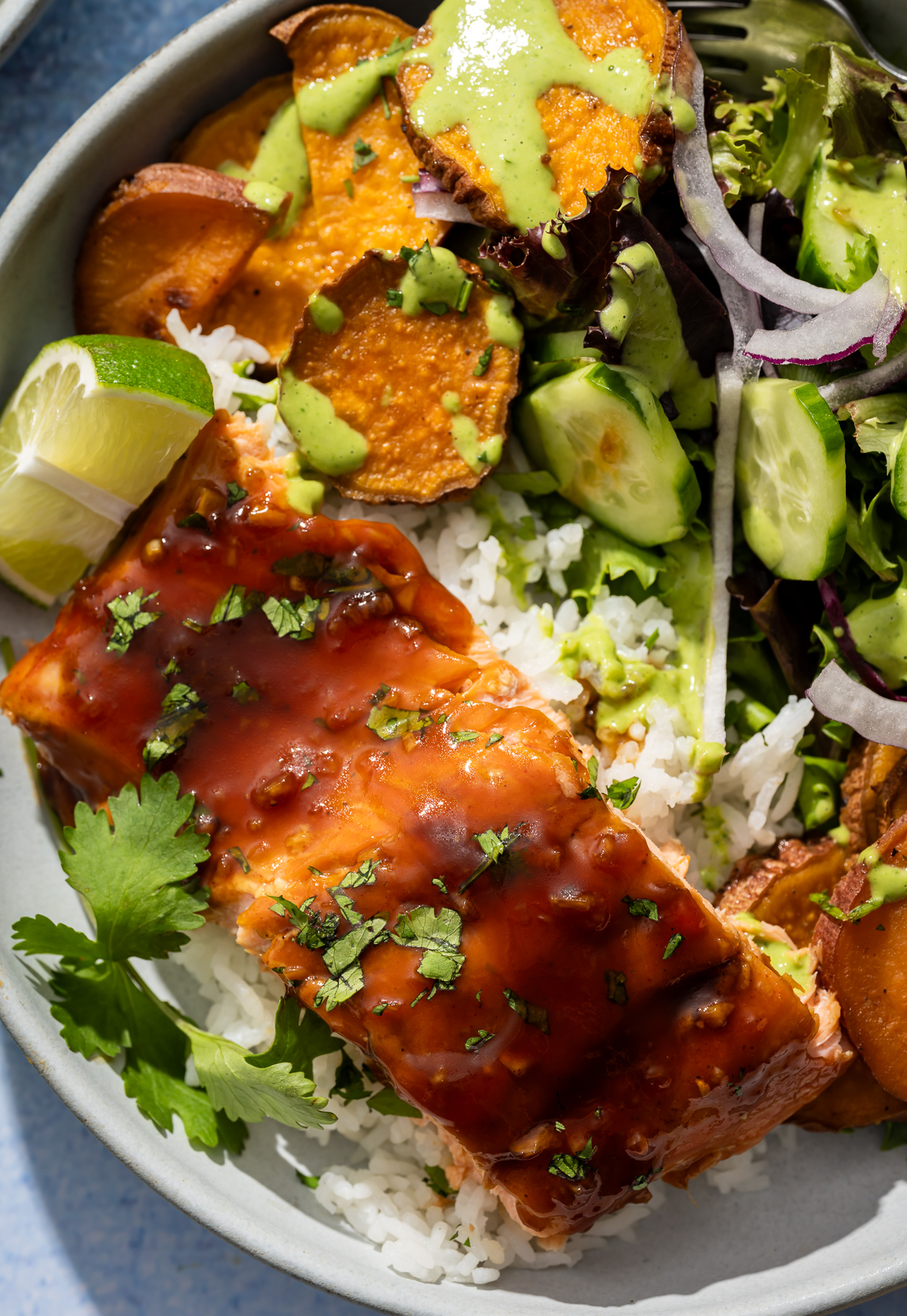 
salmon fillets in bowls with sweet potato slices salad lime slices green dressing