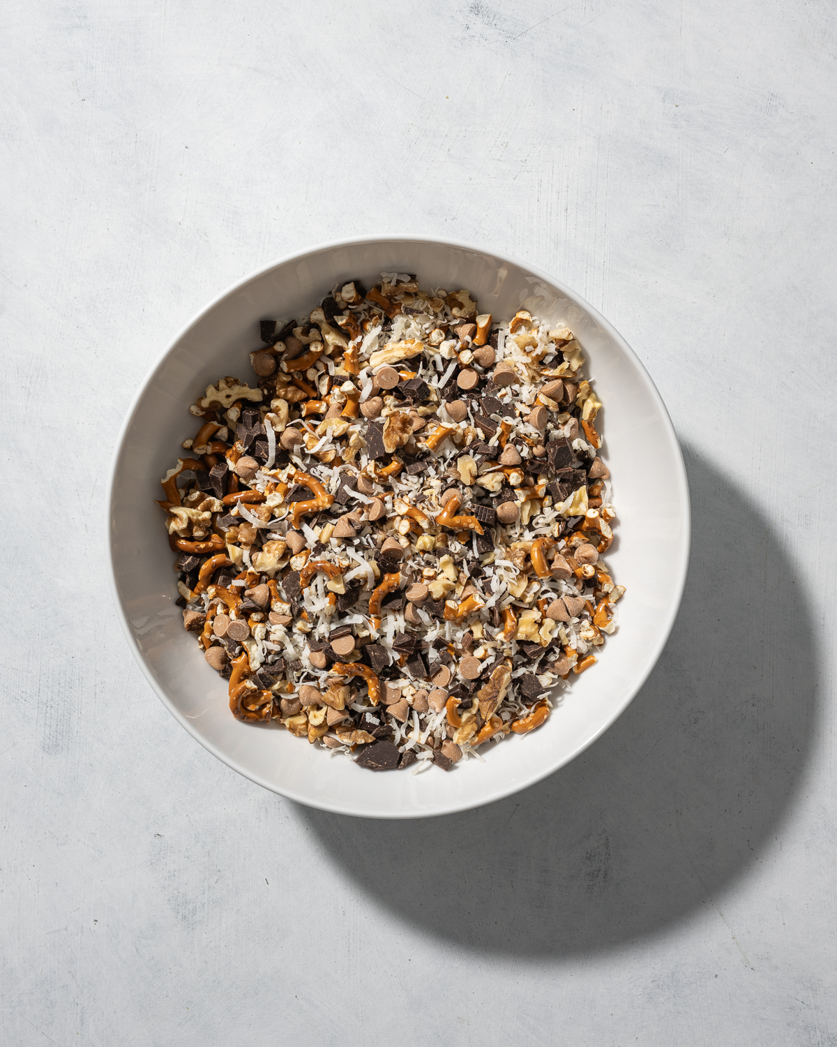 bowl of cookie mix ins pretzels chocolate caramel chips coconut walnuts